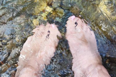 pair of bare feet in river or stream